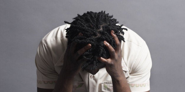 Black man, 20s, with head on hands looking frustrated