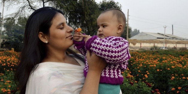 Baby offering flower to his mother.