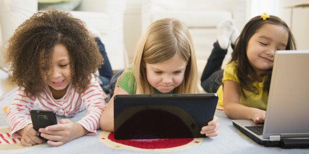 Girls using technology on carpet