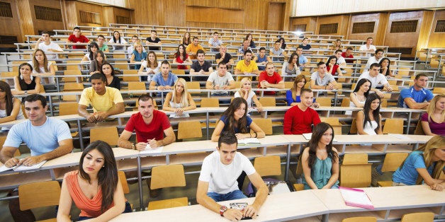 Group of college students in the university amphitheatre, they are sitting and listening to a lecture.