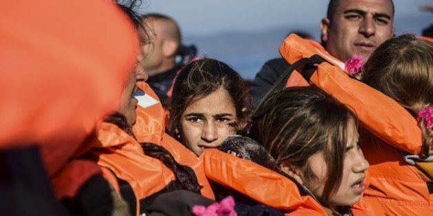 Migrants and refugees arrive on the Greek island of Lesbos after crossing the Aegean Sea from Turkey on November 18, 2015. L