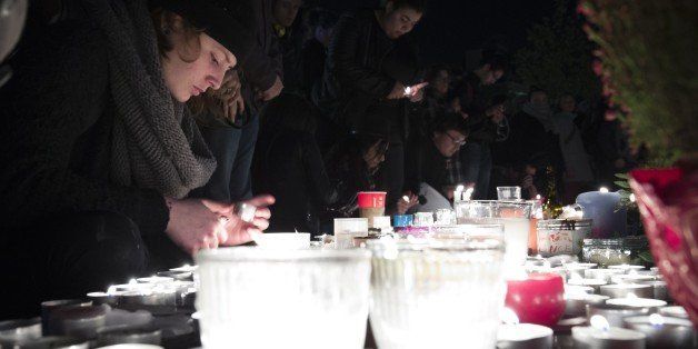 People light candles at a makeshift memorial in tribute to the victims of Paris' attacks' on November 15, 2015 at the place de la Republique in Paris. Islamic State jihadists claimed a series of coordinated attacks by gunmen and suicide bombers in Paris on November 13 that killed at least 129 people in scenes of carnage at a concert hall, restaurants and the national stadium. AFP PHOTO / JOEL SAGET (Photo credit should read JOEL SAGET/AFP/Getty Images)
