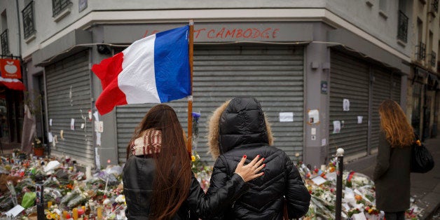 Two women stand outside the Petit Cambodge restaurant, a site of last Friday's attacks, in Paris, Tuesday, Nov. 17, 2015. Fra