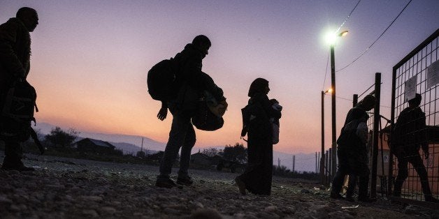 Migrants and refugees enter a registration camp after crossing the Greek-Macedonian border near Gevgelija on November 17, 201