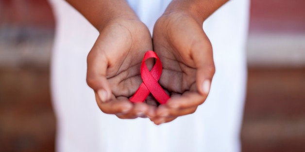 Child's hands holding an HIV awareness ribbon, Cape Town, South Africa