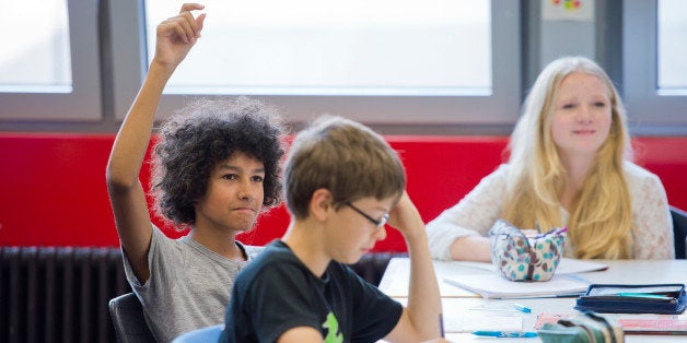 GOETTINGEN, GERMANY - SEPTEMBER 19: Posed scene: student raising his hand during a class at the Georg-Christoph-Lichtenberg-G