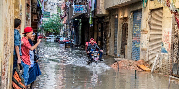 An motorcyclist rides through floodwater after a heavy rainfall in the coastal city of Alexandria, Egypt, Sunday, Oct. 25, 2015. Severe weather swept across the Middle East on Sunday, pounding Israel with baseball-sized hail, sending torrents of uncollected garbage through the streets of Beirut and killing six people in Egypt, five of whom were electrocuted by a fallen power cable. The cable from a tramway landed in streets flooded with water, electrocuting the five, senior health official Magdy Hegazy said. (AP Photo/Heba Khamis)