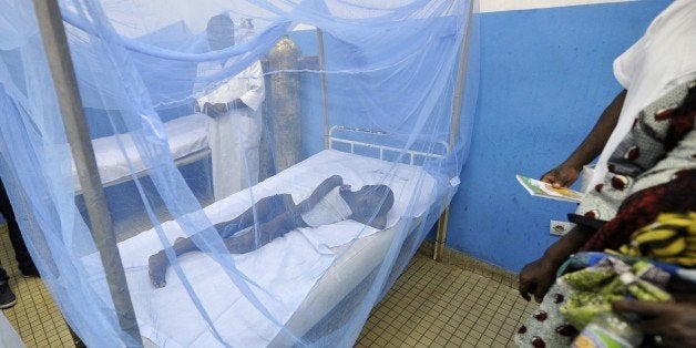A sick child lays under a mosquito net in a hospital on April 24, 2015 in the popular suburb of Port-Bouet in Abidjan, on the