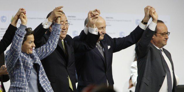Foreign Affairs Minister and President-designate of COP21 Laurent Fabius (C), raises hands with Secretary General of the United Nations Ban Ki Moon (2-L) and France's President Francois Hollande (R) after adoption of a historic global warming pact at the COP21 Climate Conference in Le Bourget, north of Paris, on December 12, 2015. Envoys from 195 nations on December 12 adopted to cheers and tears a historic accord to stop global warming, which threatens humanity with rising seas and worsening droughts, floods and storms. AFP PHOTO / FRANCOIS GUILLOT / AFP / FRANCOIS GUILLOT (Photo credit should read FRANCOIS GUILLOT/AFP/Getty Images)