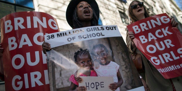 LONDON, ENGLAND - APRIL 14: Women hold a signs as other protesters gather outside Nigeria House to mark the one year anniver