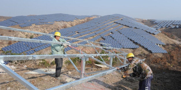 YANTAI, CHINA - NOVEMBER 17: (CHINA OUT) Workers install polycrystalline silicon solar panels as terrestrial photovoltaic power project starts in Guanshui Town of Muping District on November 17, 2015 in Yantai, Shandong Province of China. The project covering more than 300 arces of barren hills began in July and was expected to completed by end of the year, with a total installed capacity of 40 megawatts. (Photo by ChinaFotoPress/ChinaFotoPress via Getty Images)