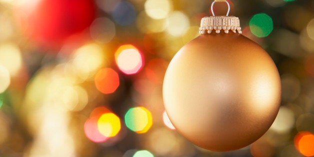 Gold Bauble Hanging On Decorated Tree