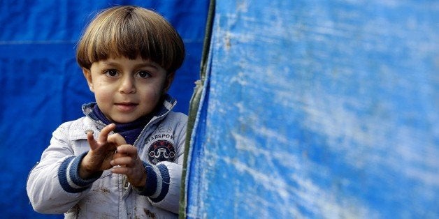 LEBANON, BEIRUT - DECEMBER 31: A Syrian child one of those who have been forced to leave their homes because of the war in their country since 2011, stands outside a makeshift tent at the Al Hayat and Al Nour refugee camp in Cabal Lebanon region, Lebanon on December 31, 2015. As the weather cools down, Syrian refugees struggle to survive heavy winter conditions at the tent city. (Photo by Ratib Al Safadi/Anadolu Agency/Getty Images)