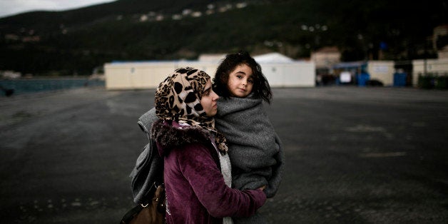 A woman from Syria holds her baby as she arrives at the registration centre on the Greek island of Samos, after being rescued