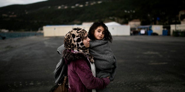 A woman from Syria holds her baby as she arrives at the registration centre on the Greek island of Samos, after being rescued by the charity Migrant Offshore Aid Station (MOAS) while attempting to reach the Greek island of Agathonisi, in Dodecanese, southeastern Aegean Sea, overnight on January 16, 2016. Maltese-based NGO MOAS (Migrant Offshore Aid Station) rescued 48 migrants and refugees near the Agathonisi island. / AFP / ANGELOS TZORTZINIS (Photo credit should read ANGELOS TZORTZINIS/AFP/Getty Images)