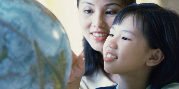Mother and her daughter looking at a globe