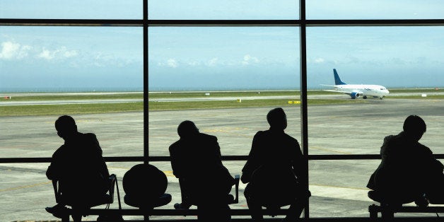 Businessmen watching airplanes on tarmac in airport