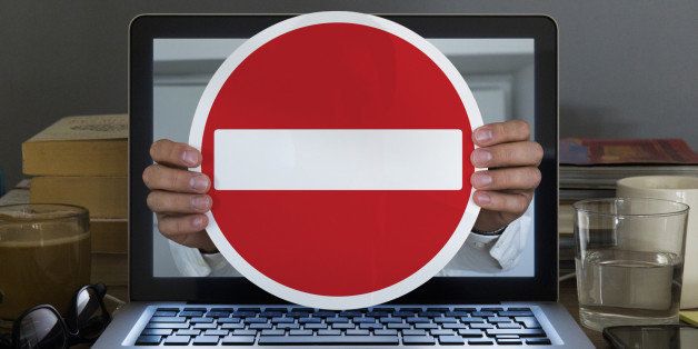 No entry sign appearing out of laptop computer