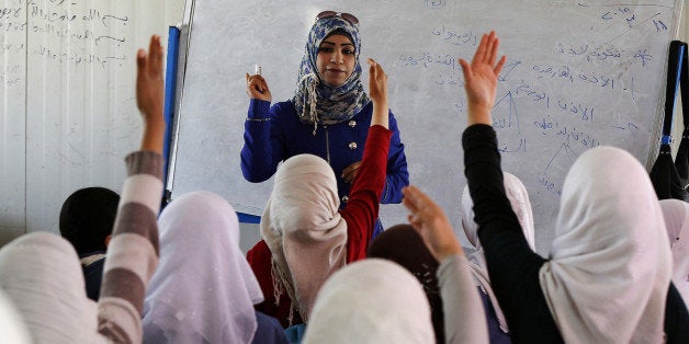 Syrian refugee children raise their hands as they attend class in a UNICEF school at the Al Zaatari refugee camp in the Jordanian city of Mafraq, near the border with Syria March 11, 2015. Nearly four million people have fled Syria since 2011, when anti-government protests turned into a violent civil war. Jordan says it is sheltering around 1.3 million refugees. REUTERS/Muhammad Hamed (JORDAN - Tags: CIVIL UNREST CONFLICT SOCIETY IMMIGRATION EDUCATION)