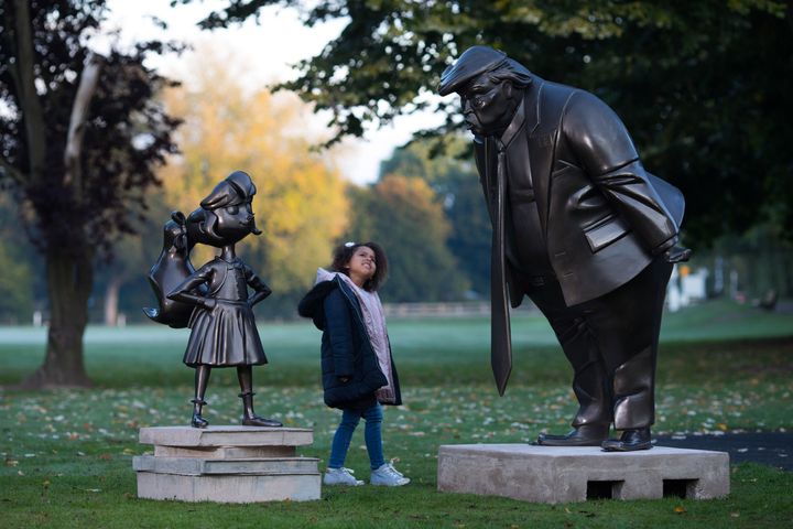 Amilie Bravington, 6, from High Wycome, takes a look at a statue of Roald Dahl's Matilda, unveiled in Great Missenden in Buckinghamshire, alongside one of President Donald Trump, to celebrate the 30th anniversary of