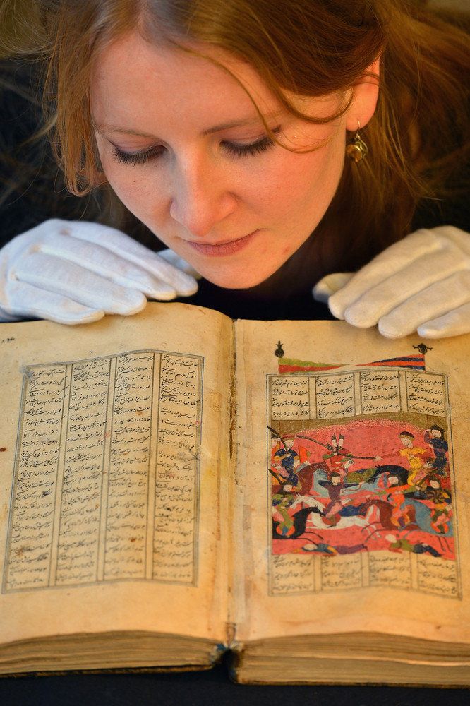 EDINBURGH, SCOTLAND - JANUARY 07: Lucy Clarke of Bonham's, views a book of poems by Jamal al-Din Abu Muhammad Nizami at an Islamic Art Exhibition at Bonham's on January 7, 2013 in Edinburgh, Scotland. The private collection of Islamic Art is due to be exhibited from January 8 - 13th at Bonham's in Edinburgh. This collection has never been seen in public before and is Scotland's largest private and internationally important collection of Islamic art including over 650 items from pre-Islamic and Islamic culture. Primarily featuring objects from the Land of Timur, Central Asia; those on display are ancient ceramics, bronzes, books, goblets, glass, furniture, paintings, textiles and coins. (Photo by Jeff J Mitchell/Getty Images)