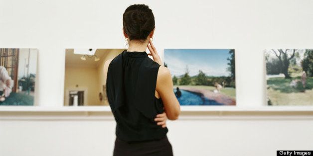 Woman looking at photographs in gallery, rear view