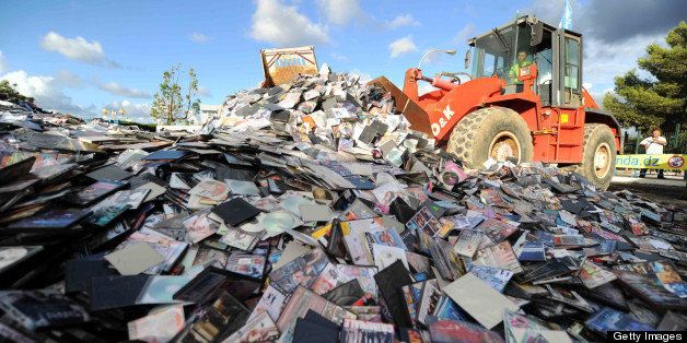 Over one million pirated CDs and DVDs are destroyed by a bulldozer during an event organised by Algeria's national office of copyright and related rights in Algiers on October 15, 2012 as part of an anti-piracy campaign by authorities. AFP PHOTO/FAROUK BATICHE (Photo credit should read FAROUK BATICHE/AFP/Getty Images)