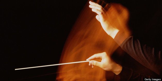 Orchestra conductor waving baton, close-up (blurred motion)