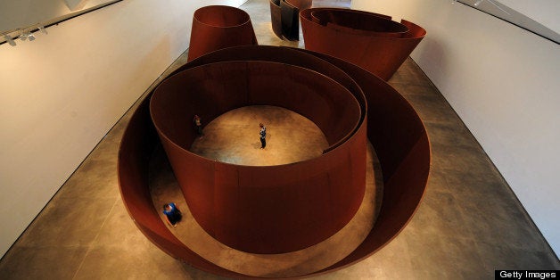 People walk among US artist Richard Serra's sculptures 'The Matter of Time', during the presentation of the Guggenheim Bilbao