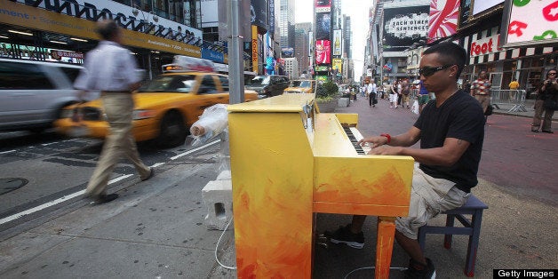 NEW YORK - JUNE 21: Allan Decipulo play a piano in Times Square as part of the 'Play Me, I?m Yours' public art installation by British artist Luke Jerram on June 21, 2010 in New York City. The two-week project started June 21 and places 60 pianos open for public play in various parts of the city. (Photo by Mario Tama/Getty Images)