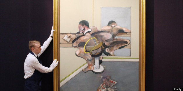 LONDON, ENGLAND - APRIL 12: A gallery technician at Sotheby's auction house adjusts a painting by Francis Bacon entitled 'Fi