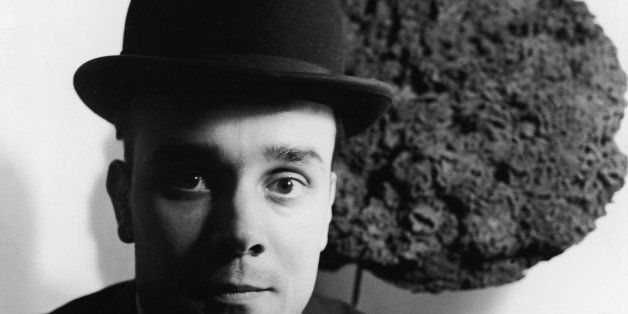 Black and white portrait of French artist Yves Klein (1928 - 1962) in a bowler hat as he stands in front of one of his Blue Sponge Sculptures, France, late 1950s. The first public display of these sculptures, which were made from different sized sponges that had been dyed blue, was on June 15, 1959 at the Galerie Iris Clert in Paris, France. (Photo by Express Newspapers/Getty Images)