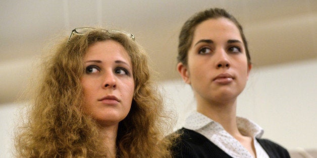 Members of the Russian punk rock band Pussy Riot Maria Alyokhina (L) and Nadezhda Tolokonnikova (R) attend a preview of the nominees for the inaugural Prudential Eye Awards in Singapore on January 17, 2014. The two members of Russian punk band Pussy Riot made their first international appearance since their release from prison last month, ahead of the awards ceremony for emerging Asian artists for which their anti-Putin video is shortlisted. AFP PHOTO / ROSLAN RAHMAN (Photo credit should read ROSLAN RAHMAN/AFP/Getty Images)