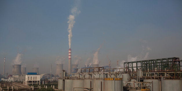 Vapor rises from cooling towers at a power plant, background, at the China Hongqiao Group Ltd. aluminum smelting facility in