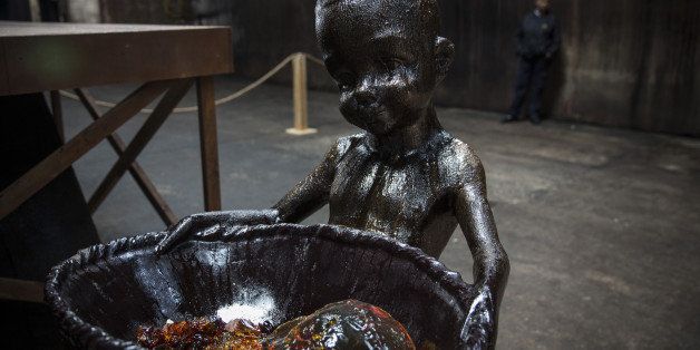 NEW YORK, NY - MAY 10: Sculptures depicting child laborers, made in part out of unrefined sugar, is displayed as a part of artist Kara Walker's 'A Subtlety,' at the former Domino Sugar Refinery on May 10, 2014 in the Williamsburg neighborhood of the Brooklyn borough of New York City. The main display of the show is a seventy-five and a half feet long and thirty-five and a half feet tall sphnix made in part of bleached sugar. The show opened today, is free to the public and will run until July 6th. (Photo by Andrew Burton/Getty Images)