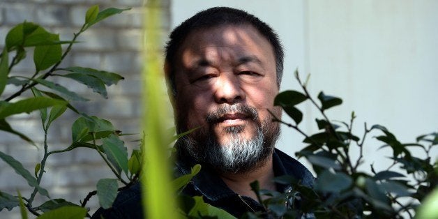 China's best known and boldest contemporary artist, Ai Weiwei, poses in the garden of his studio in the suburbs of Beijing on April 3, 2014. The biggest-ever exhibition by Ai Weiwei opens in Berlin's Martin Gropius Bau museum with his signature brand of politically explosive works given pride of place. AFP PHOTO/GOH CHAI HIN (Photo credit should read GOH CHAI HIN/AFP/Getty Images)