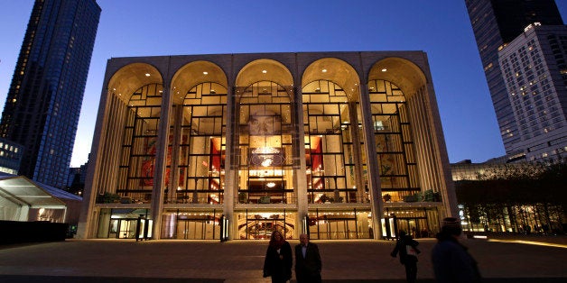 Pedestrians stroll at dusk in Josie Roberston Plaza near the Metropolitan Opera House in Lincoln Center, Wednesday, Nov. 13, 2013, in New York. (AP Photo/Kathy Willens)