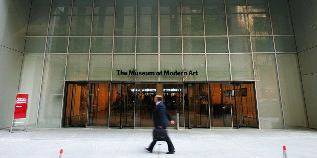 NEW YORK - NOVEMBER 17: A pedestrian walks outside the entrance to the new Museum of Modern Art building on 53rd Street November 17, 2004 in New York City. The new Yoshio Taniguchi-designed building opens to the public November 20. (Photo by Chris Hondros/Getty Images)