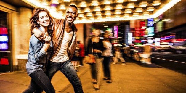 Couple having fun at night on Broadway, New York City.