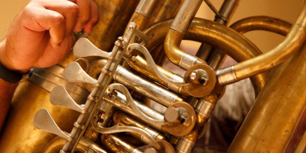 Atlanta Falcons guard Justin Blalock plays the tuba during a rehearsal for a concert featuring youth musicians and members of