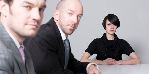 young woman sitting at conference table with two businessmen