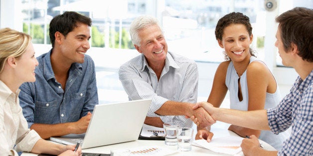 Mixed group in business meeting having a discussion shaking hands