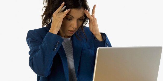 Extremely frustrated businesswoman with laptop on table, close-up