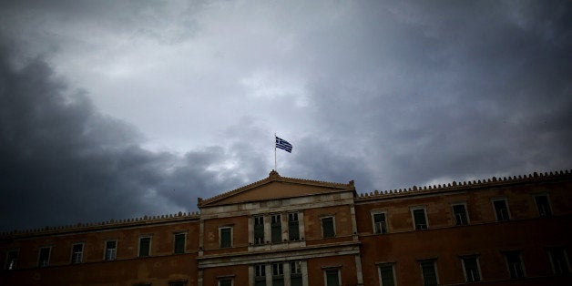 A Greek flag waves at the top of the Greek Parliament on May 22, 2016.
Greece on May 22, 2016 was set to adopt fresh cuts a