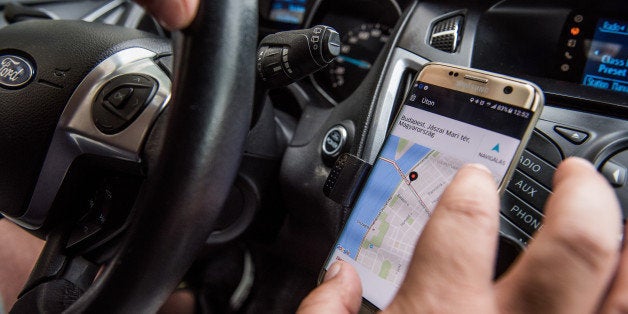 A driver uses a Samsung Electronics Co. Galaxy edge smartphone displaying the Uber Technologies Inc. car service taxi application (app) to pick up a passenger in this arranged photograph in Budapest, Hungary, on Wednesday, July 13, 2016. Uber will suspend its ride-hailing services in Hungary from July 24 following a government decision to pass a bill that allows authorities to block access to the mobile application and fine media promoting it. Photographer: Akos Stiller/Bloomberg via Getty Images