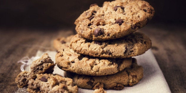 Chocolate chip cookies on linen napkin on wooden table. Stacked chocolate chip cookies close up.