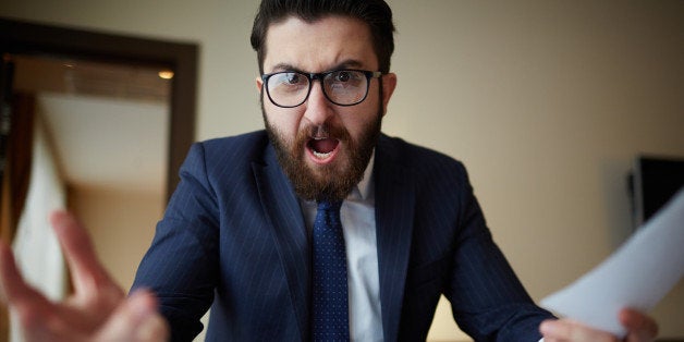 Angry businessman with document shouting at somebody