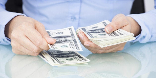 Close-up Of A Businesswoman Counting Bank Note At Desk