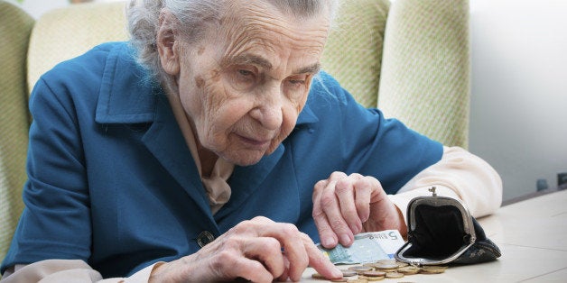 elderly caucasian woman counting coins in her hands