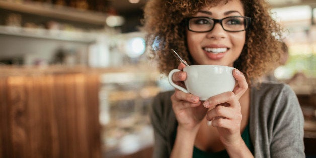 Photo of a young woman enjoying morning coffee in cafe